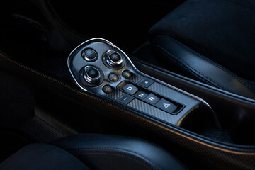 Obraz premium Interior close up of luxury British sport car carbon fiber center console with transmission buttons and start stop control. High performance design featuring premium materials and modern ergonomics