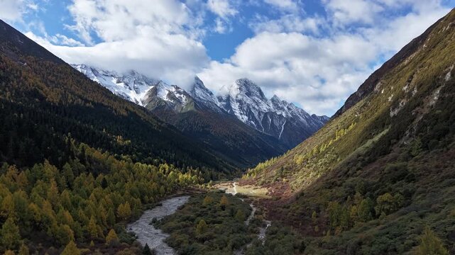 Hyperlapse aerial footage of autumn snow mountain landscape in Jiesigou, Sichuan, China. With dramatic cloudscape and fall colors.