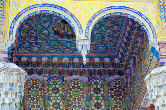 Fragment ceiling of facade of the iwan of the Bolo Haouz Mosque at Bukhara, Uzbekistan. The arched facade is decorated yellow and blue intricate geometric patterns. Islamic architecture