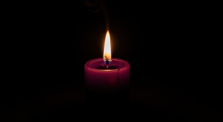 A single lit candle with a dark background.