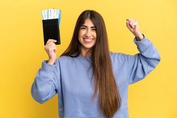 Young caucasian woman holding a passport isolated on yellow background doing strong gesture
