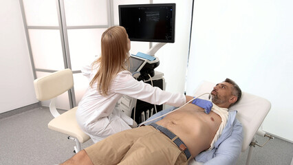 Heart ultrasound exam for adult man with ultrasound specialist while medical exam at hospital