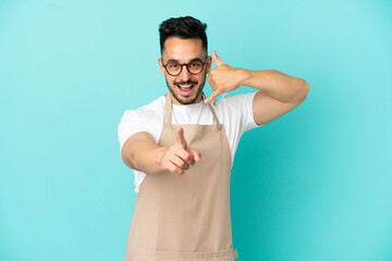 Fototapeta premium Restaurant waiter caucasian man isolated on blue background making phone gesture and pointing front