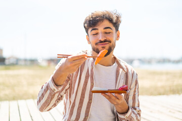 Handsome Arab man at outdoors holding sashimi