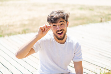 Handsome Arab man at outdoors With glasses and frustrated expression