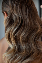 Naklejka premium Beautiful flowing hair with soft waves and subtle highlights, showcasing elegance and shine in a modern, natural setting