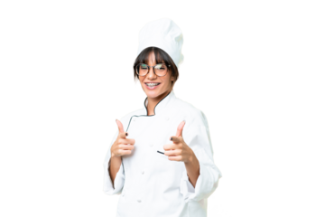 Young caucasian chef  woman over isolated chroma key background pointing to the front and smiling