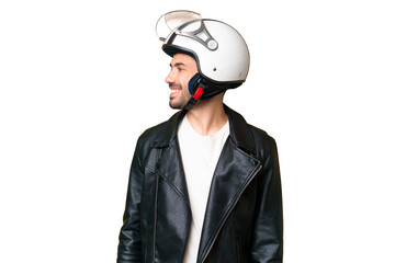 Young caucasian man with a motorcycle helmet over isolated chroma key background looking side