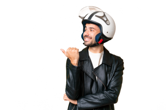 Young caucasian man with a motorcycle helmet over isolated chroma key background pointing to the side to present a product