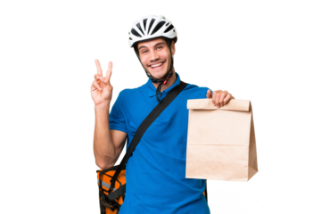 Young caucasian man taking a bag of takeaway food over isolated background smiling and showing victory sign
