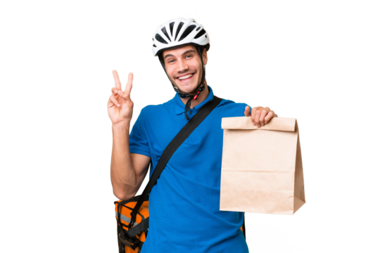 Young caucasian man taking a bag of takeaway food over isolated background smiling and showing victory sign