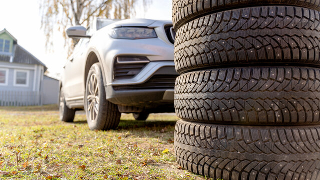 Car and winter tires on the lawn. Seasonal Tyre Replacement Concept