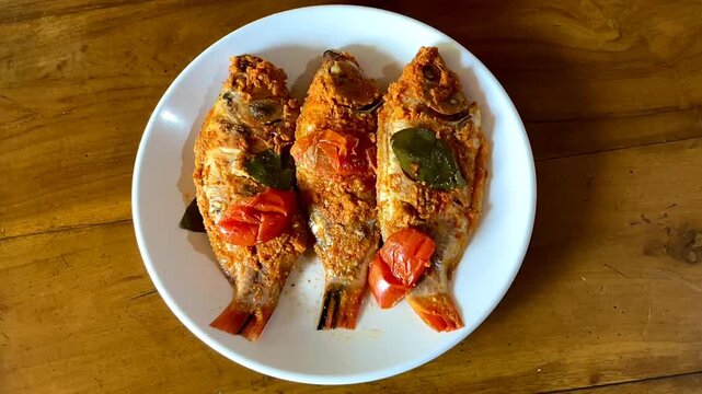 Indonesian food: pepes ikan nila (steamed nile tilapia with spices). Spices are smeared on tilapia's body, wrapped with banana leave, and then steamed. 