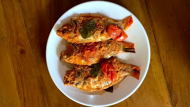 Indonesian food: pepes ikan nila (steamed nile tilapia with spices). Spices are smeared on tilapia's body, wrapped with banana leave, and then steamed. 