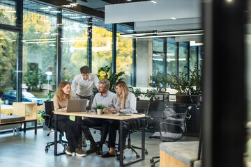 Business office with people casual wear, with blurred bokeh background, view from glass wall