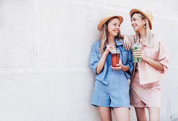 Two young beautiful smiling hipster female in trendy summer clothes. Carefree women posing...