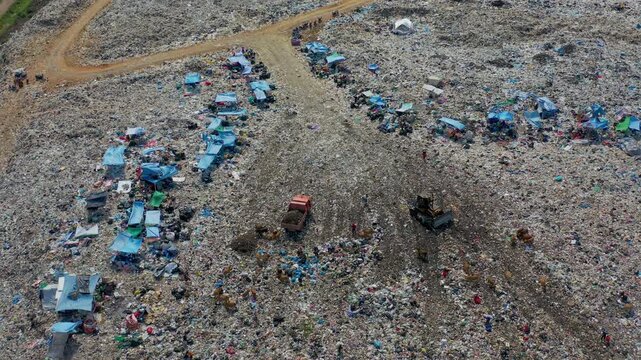 Aerial 4K: Waste Pickers, Bulldozer, and Garbage Truck Working at Massive Landfill