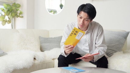 督促状を確認するアジア人男性