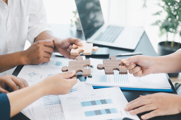 Business teamwork concept with people holding wooden puzzle pieces together, symbol of collaboration, strategy, problem solving, partnership and corporate success in modern office. business teamwork.