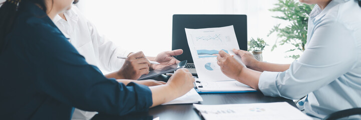 Panorama of corporate teamwork with people discussing financial reports, pointing at charts,...