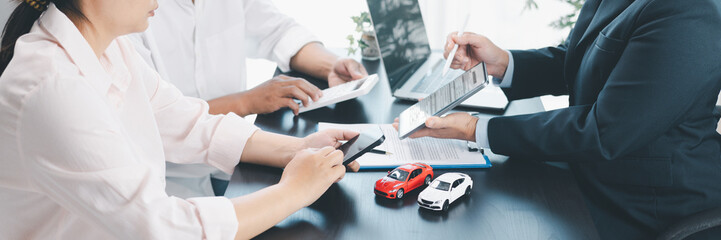 Panorama view of car loan agreement signing with dealer presenting vehicle model, customer using...