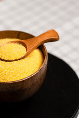 Freshly milled corn grits in a wooden bowl ready for cooking or baking