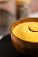 Fresh corn grits in a wooden bowl ready for cooking in a cozy kitchen setting