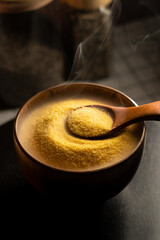 Steaming bowl of corn grits with wooden spoon ready for breakfast enjoyment
