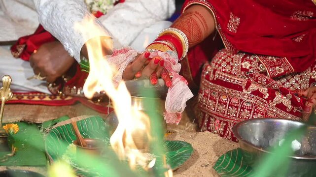 Hands of the bride and groom in wedding Ceremony. Hindu wedding ritual. Odia Wedding. Hindu Wedding Ceremony with Burning Fire and Offering Ritual with People and Golden Details.