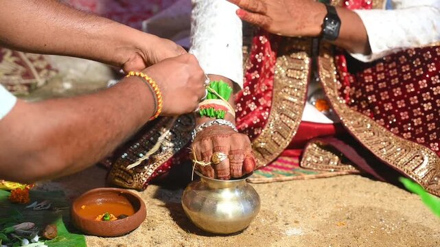 Hands of the bride and groom in wedding Ceremony. Hindu wedding ritual. Odia Wedding. Hindu Wedding Ceremony with Burning Fire and Offering Ritual with People and Golden Details.