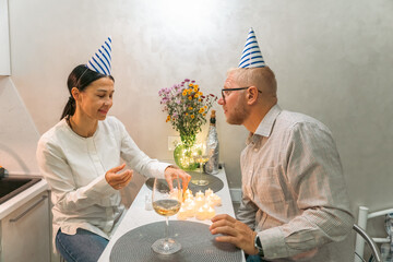 Couple Birthday Candles Kitchen: Celebrating anniversary, intimate home setting, joyful moment.