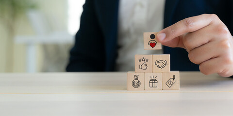 Building customer loyalty and trust concept. Wooden blocks with icons for loyalty, rewards, trust, support, quality, price and satisfaction. Brand loyalty and customer relationship growth.