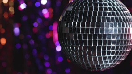 Glittering disco ball spinning reflects light, creating a festive and energetic party atmosphere - Powered by Adobe