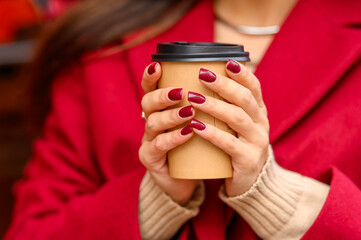 Coffee to go. Young woman with coffee in the autumn park