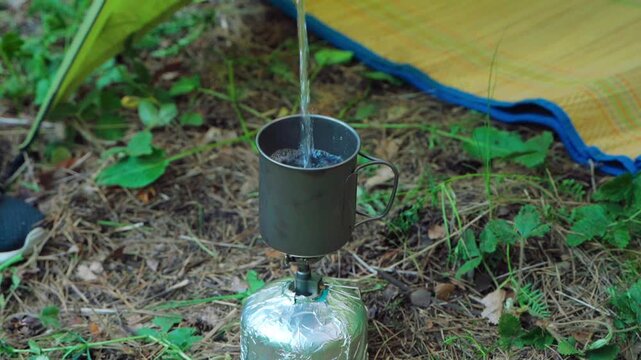 Girl hiking alone in a summer forest. Making tea or coffee outdoors.