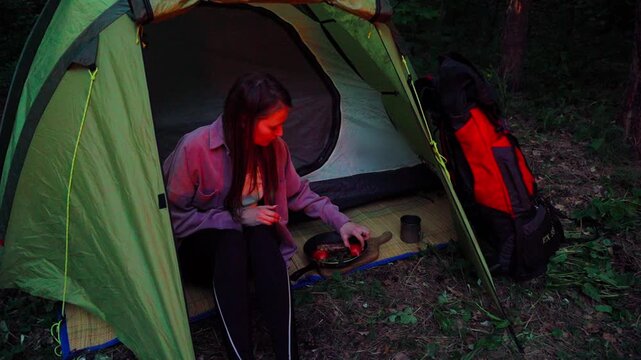 Girl hiking alone in a summer forest. Cooking in the forest