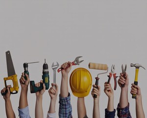 Group of construction and repair workers raising various essential tools high up in the air, including a hard hat and drill