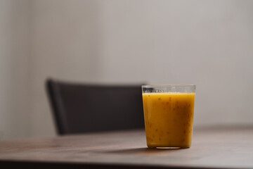 Mango lulo smoothie on walnut wood table with copy space