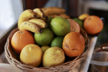 Fresh fruit basket with ripe banana, orange, lime, and guava. vibrant and colorful assortment of healthy food offering delicious, natural, and nutritious snack in woven bowl