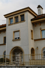 Elegant architecture of a residential house with arched doorway, yellow details and white walls