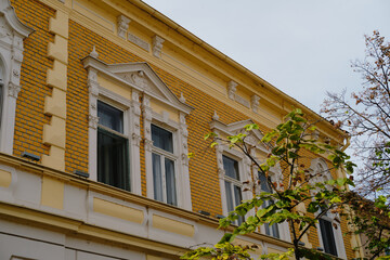 Decorative yellow brick facade with white window frames and classic architectural details