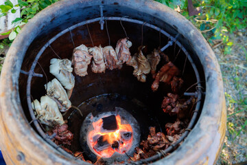 A man grills pork in a crispy, fragrant pot at a party. The crispy pork chops are a popular dish in...