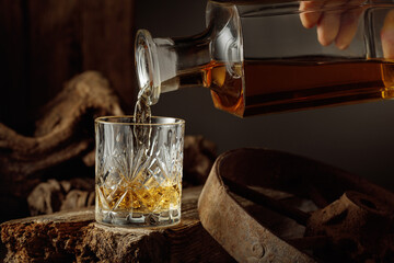 Whiskey is poured from a decanter into a glass.