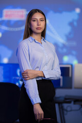 Confident professional in a command center with data visualizations on screen