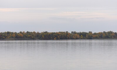 Autumn landscape with a lake and trees on the shore in the evening