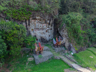 Aerial view of the cliff burial site with traditional Tongkonan structures in Lemo, Tana Toraja, Indonesia.  
