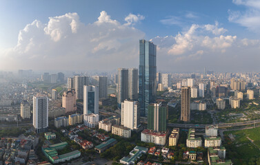 Obraz premium Panoramic view of Hanoi city center with tall towers, green parks, and bright afternoon light.