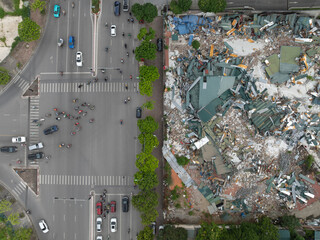 Aerial top-down view of Hanoi intersection beside a demolished site, showing vehicles and traffic...