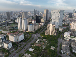 Aerial view of modern Hanoi district with wide streets, tall buildings, and tree-lined urban layout.