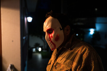 Portrait of a man wearing a hockey mask on Halloween. Murderer, murder, cruel and homicidal.